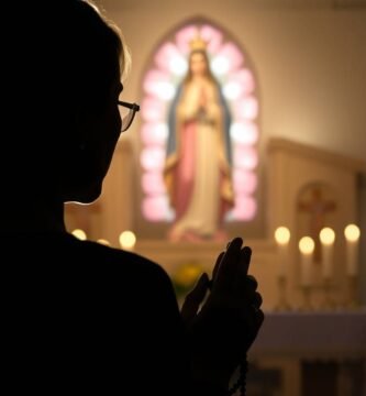 Ujęcie z dołu, w świetle kobiety modlącej się w kaplicy z obrazem Matki Boskiej w centrum