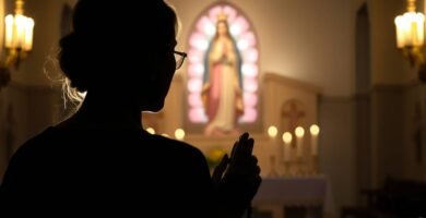 Ujęcie z dołu, w świetle kobiety modlącej się w kaplicy z obrazem Matki Boskiej w centrum