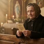 Obraz starszej kobiety modlącej się w pustym kościele z różańcem w dłoniach
